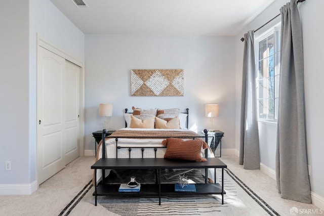 bedroom with light carpet and a closet