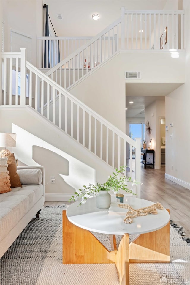 living room featuring a high ceiling and hardwood / wood-style floors