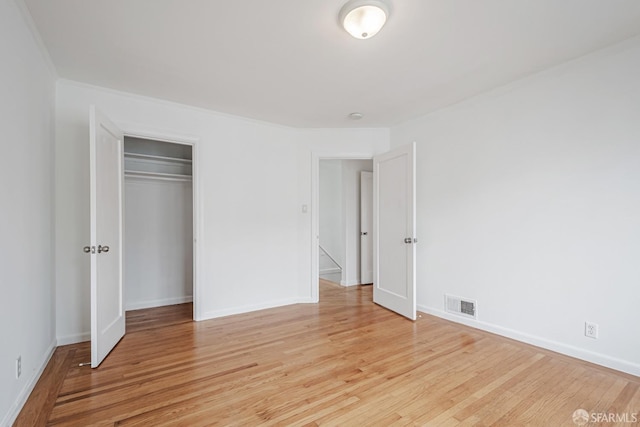 unfurnished bedroom with light wood-style flooring, visible vents, and baseboards