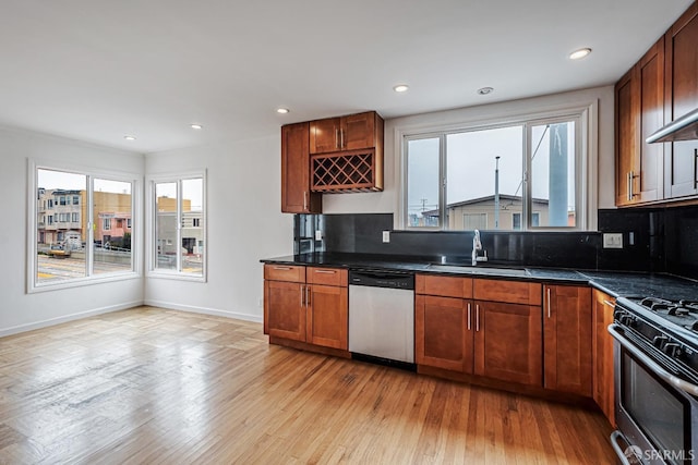 kitchen with dark countertops, decorative backsplash, stainless steel appliances, and a sink