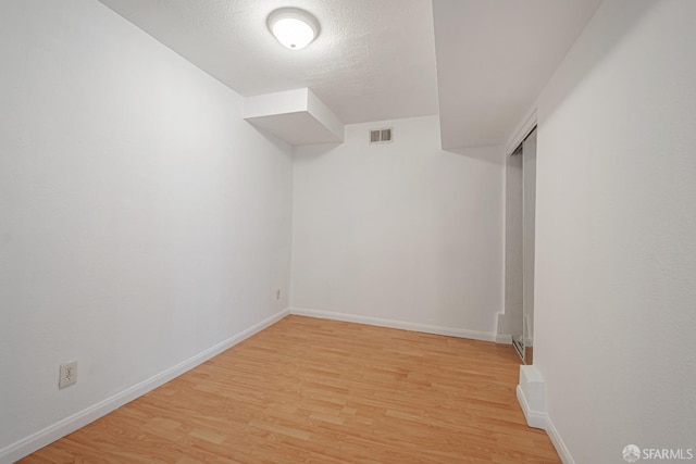 additional living space featuring baseboards, visible vents, and light wood-style flooring