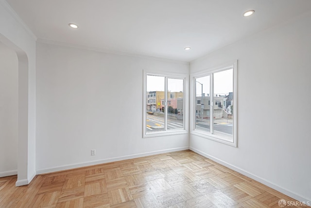 spare room with arched walkways, baseboards, ornamental molding, and recessed lighting