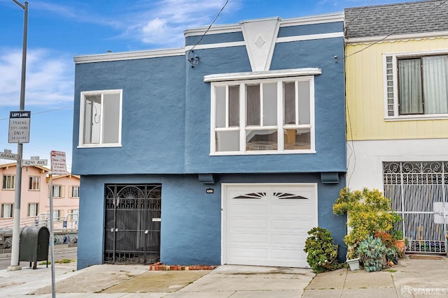 townhome / multi-family property with stucco siding, an attached garage, fence, and heating fuel