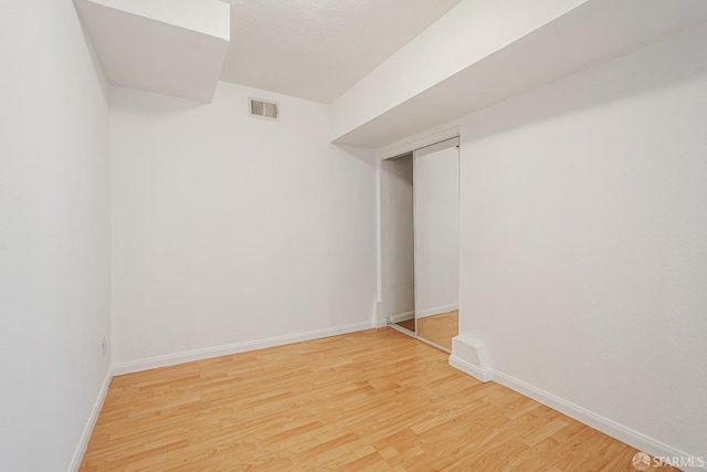 interior space with baseboards, visible vents, and light wood-style flooring