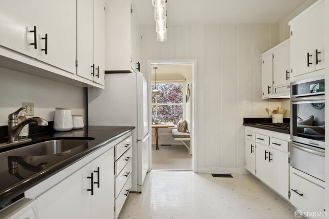 773 15th Ave, San Francisco, CA 94118 - kitchen featuring stainless steel oven, a warming drawer, white cabinets, light floors, and dark countertops