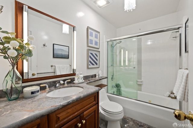 full bathroom featuring enclosed tub / shower combo, vanity, and toilet