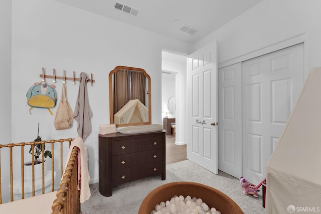 bedroom featuring light colored carpet and a closet