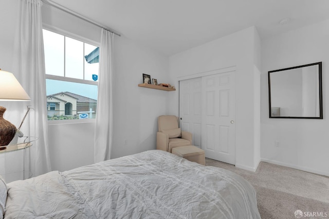 bedroom with light colored carpet and a closet