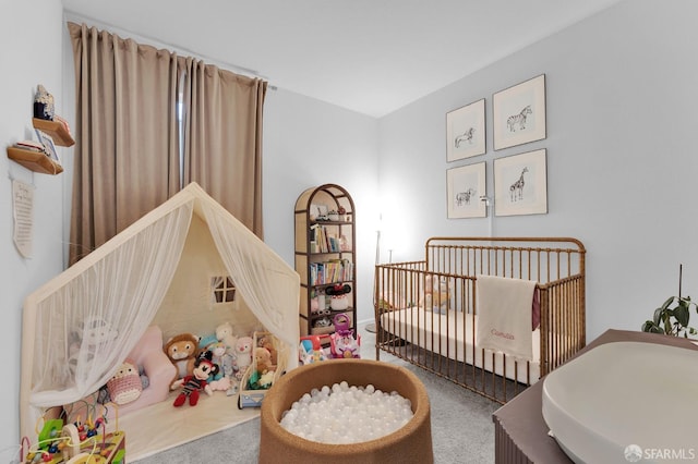 carpeted bedroom with a nursery area