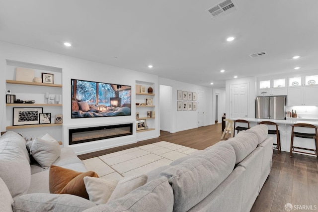 living room with hardwood / wood-style floors and built in shelves