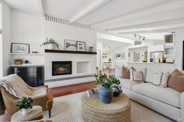703 W St, Petaluma, CA 94952 - living area featuring wood finished floors, beamed ceiling, and a brick fireplace