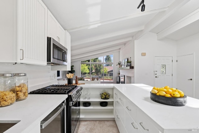 703 W St, Petaluma, CA 94952 - kitchen featuring stainless steel microwave, gas range, light countertops, white cabinets, and beamed ceiling