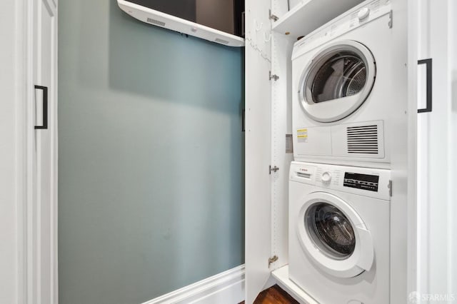 clothes washing area featuring stacked washer and clothes dryer