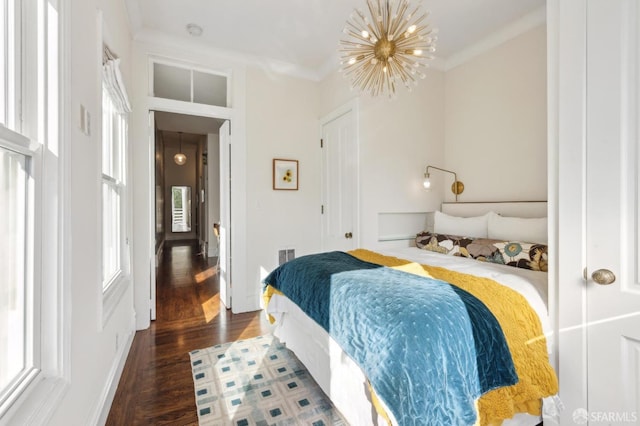 bedroom featuring crown molding, a chandelier, and dark hardwood / wood-style flooring