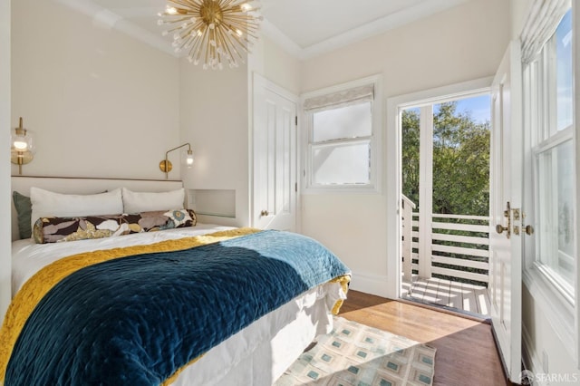 bedroom featuring ornamental molding, access to exterior, a chandelier, and wood-type flooring