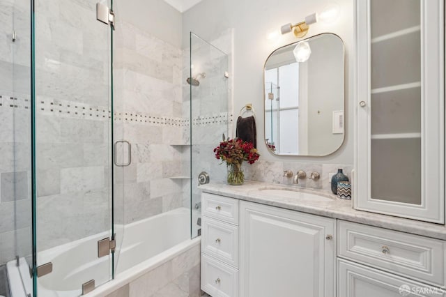 bathroom featuring bath / shower combo with glass door and vanity