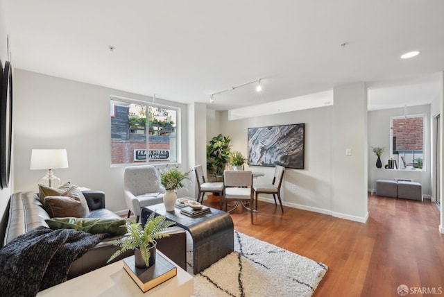 living area featuring track lighting, recessed lighting, baseboards, and wood finished floors