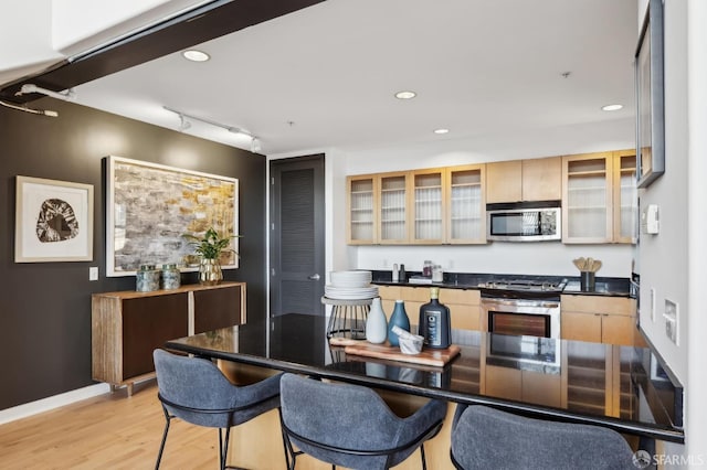 kitchen featuring light wood-type flooring, light brown cabinetry, appliances with stainless steel finishes, and track lighting