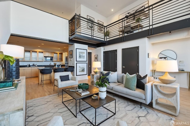 living room with a high ceiling and light wood-type flooring