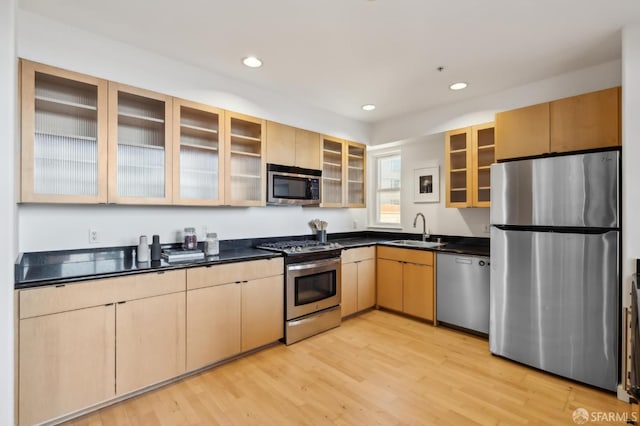 kitchen with light hardwood / wood-style floors, sink, stainless steel appliances, and light brown cabinets