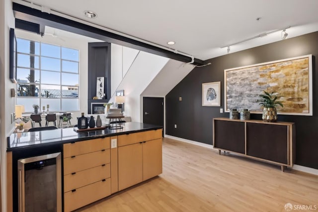 kitchen with light hardwood / wood-style flooring, beverage cooler, track lighting, and light brown cabinets