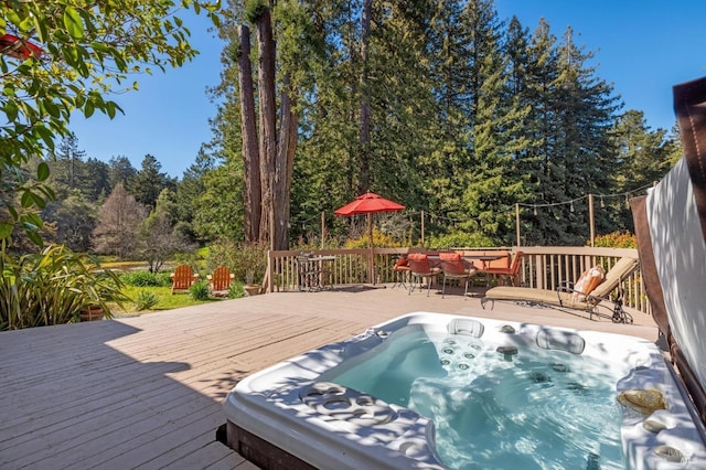 wooden deck with outdoor dining area and hot tub deck surround
