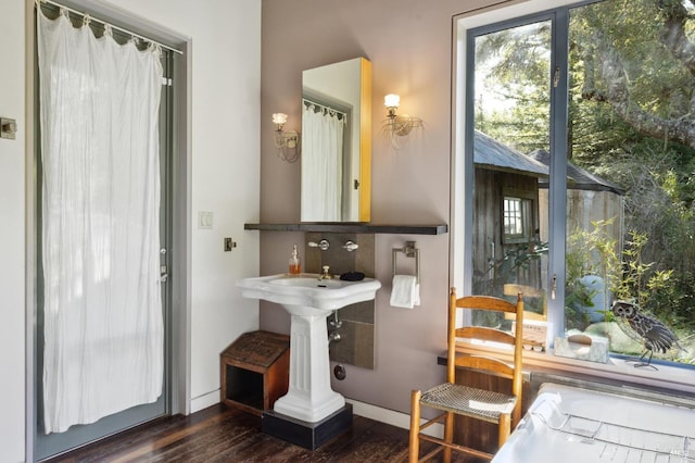 bathroom with baseboards and wood finished floors