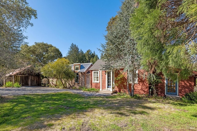 view of property hidden behind natural elements featuring a front lawn