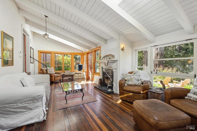living area featuring vaulted ceiling with beams, a fireplace with raised hearth, and hardwood / wood-style floors