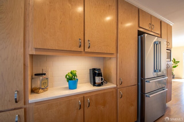 569 Peralta Ave, San Francisco, CA 94110 - kitchen with high end fridge, backsplash, wood finished floors, and brown cabinetry