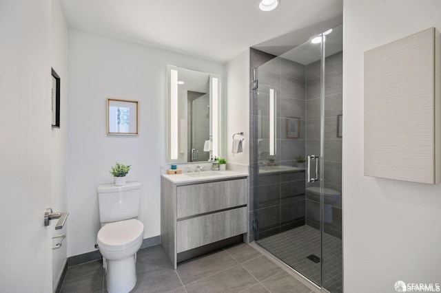 bathroom featuring tile patterned flooring, a shower with shower door, vanity, and toilet