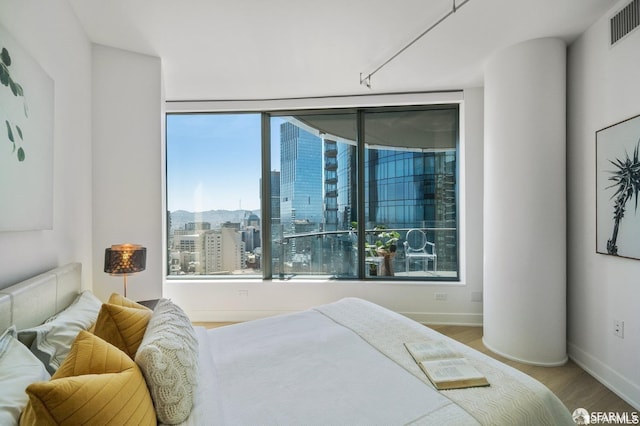 338 Main St Unit 35E, San Francisco, CA 94105 - bedroom featuring a city view, multiple windows, wood finished floors, and visible vents