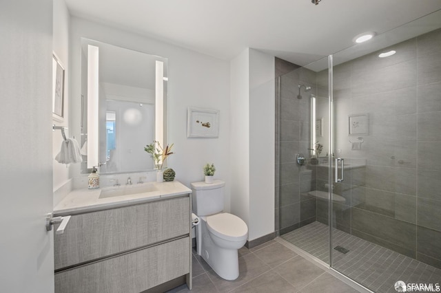 bathroom with vanity, toilet, a shower with door, and tile patterned floors