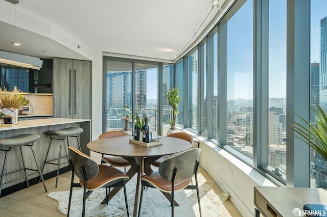 dining area featuring a wall of windows and light wood-type flooring