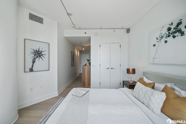 bedroom with hardwood / wood-style floors and a closet