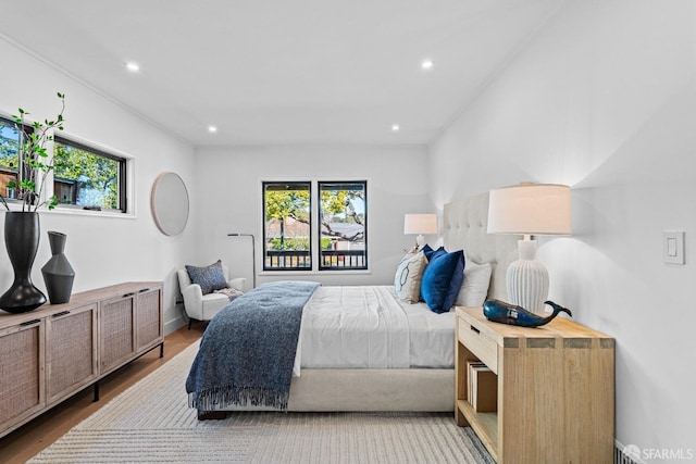 bedroom with multiple windows and light wood-type flooring