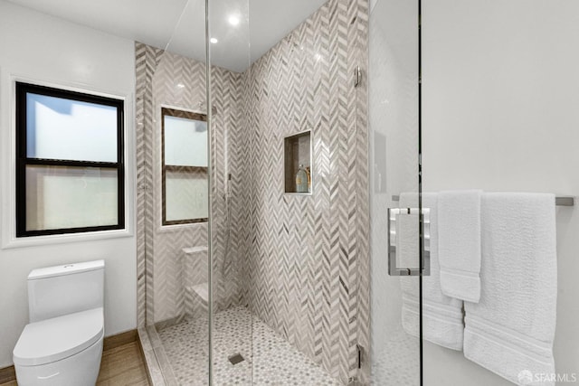 bathroom with an enclosed shower and toilet