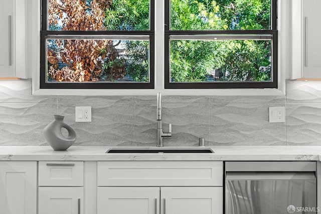 kitchen featuring white cabinetry, dishwasher, sink, and tasteful backsplash