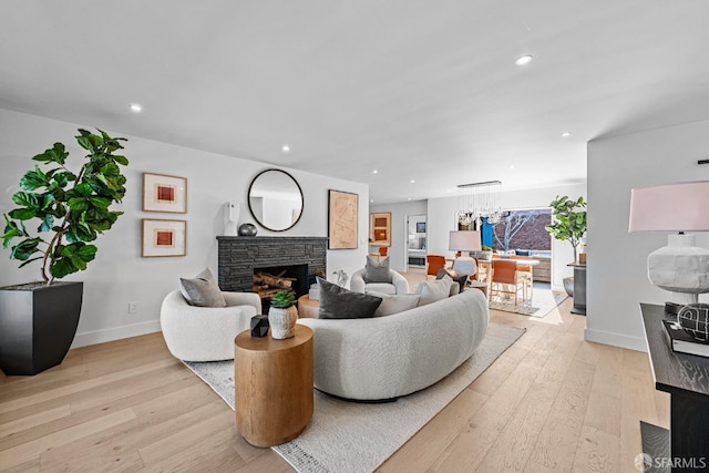 living room featuring a stone fireplace and light hardwood / wood-style flooring