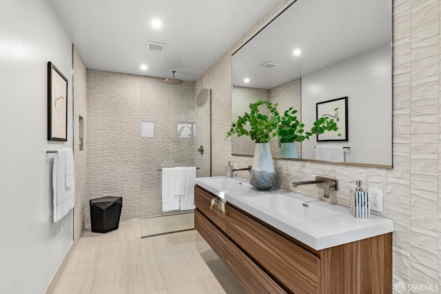 bathroom with vanity, tile walls, and walk in shower