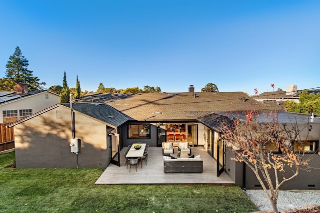 rear view of property with a wooden deck, outdoor lounge area, and a lawn