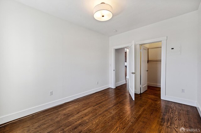 1375 Sacramento St, San Francisco, CA 94109 - unfurnished bedroom featuring dark wood finished floors, baseboards, a spacious closet, and a closet