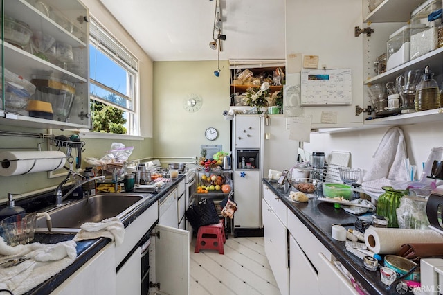 1375 Sacramento St, San Francisco, CA 94109 - kitchen with white gas range, white cabinetry, dark countertops, and rail lighting