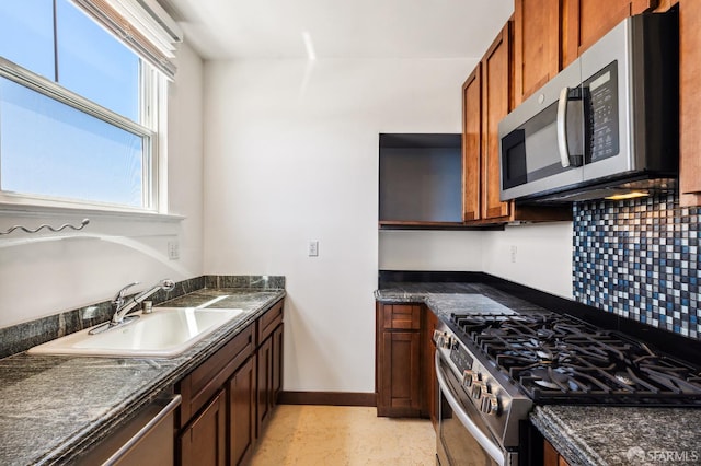 1375 Sacramento St, San Francisco, CA 94109 - kitchen with stainless steel appliances, dark countertops, a sink, backsplash, and baseboards