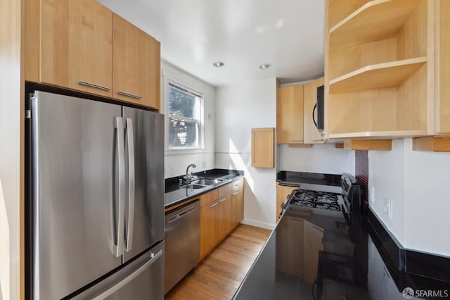 1375 Sacramento St, San Francisco, CA 94109 - kitchen featuring stainless steel appliances, a sink, open shelves, light wood-style flooring, and baseboards