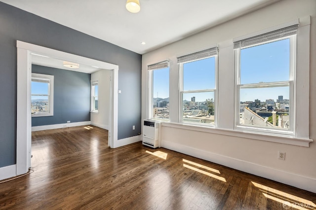 1375 Sacramento St, San Francisco, CA 94109 - spare room featuring baseboards, wood finished floors, heating unit, a city view, and recessed lighting