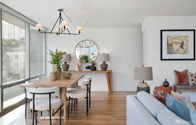 dining area with expansive windows, wood finished floors, and a chandelier