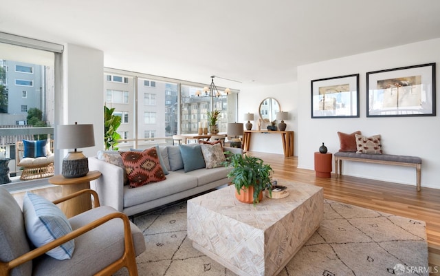 living room featuring a chandelier, expansive windows, and wood finished floors