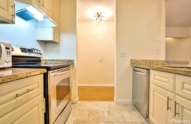 kitchen featuring light stone countertops, stainless steel appliances, and light tile patterned floors