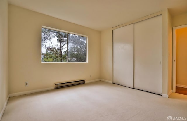 unfurnished bedroom with a baseboard radiator, light colored carpet, and a closet